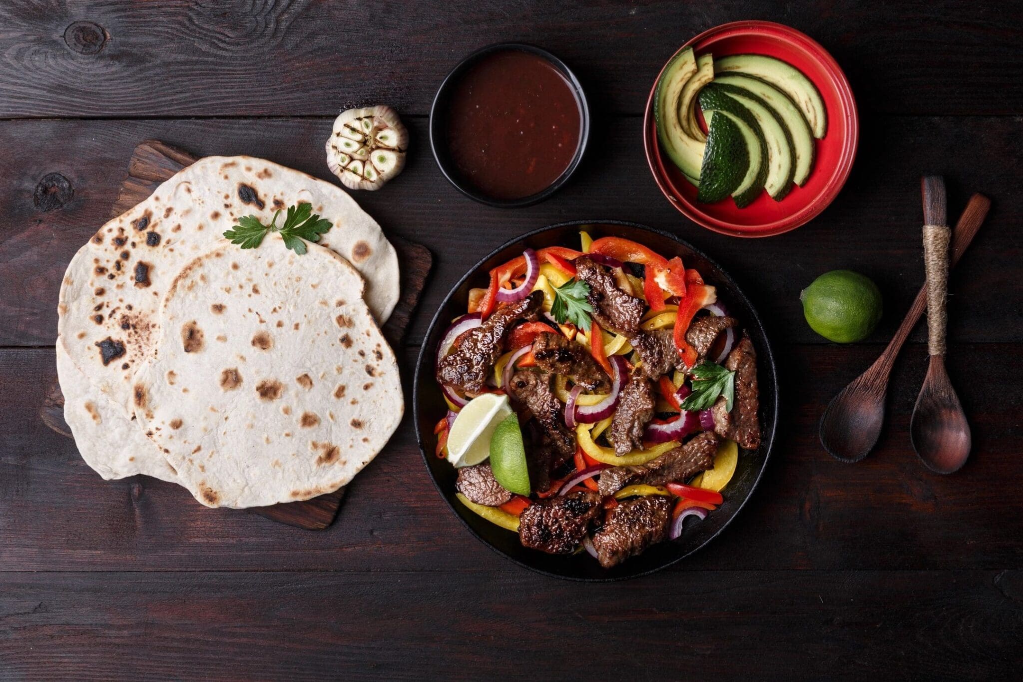 A table with some food and tortillas on it