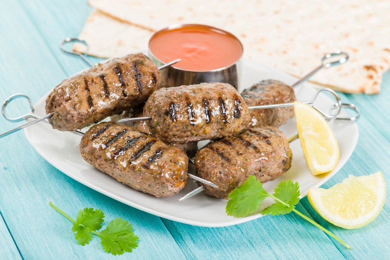 A plate of food with meat on skewers.