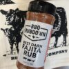 A jar of bbq rub sitting on top of a towel.