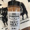 A jar of bbq rub sitting on top of a table.