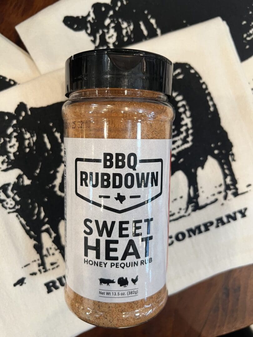 A jar of bbq rub sitting on top of a table.