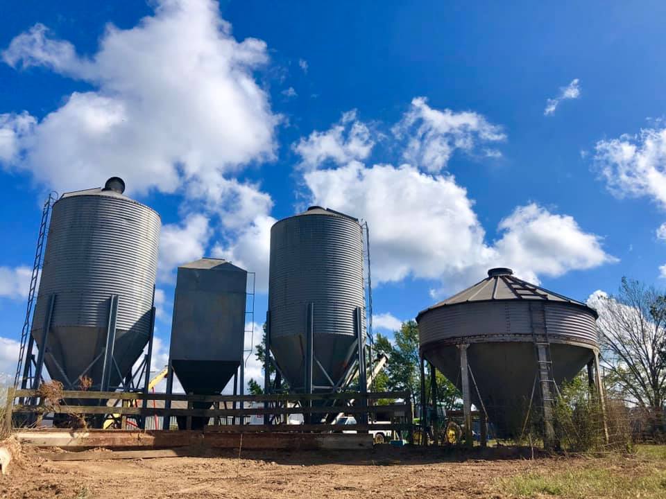 A group of silos sitting on top of a dirt field.